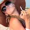 attractive woman in a hat smoking a cigarette