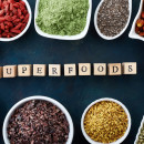 Bowls of various superfoods on old blue background. Top view